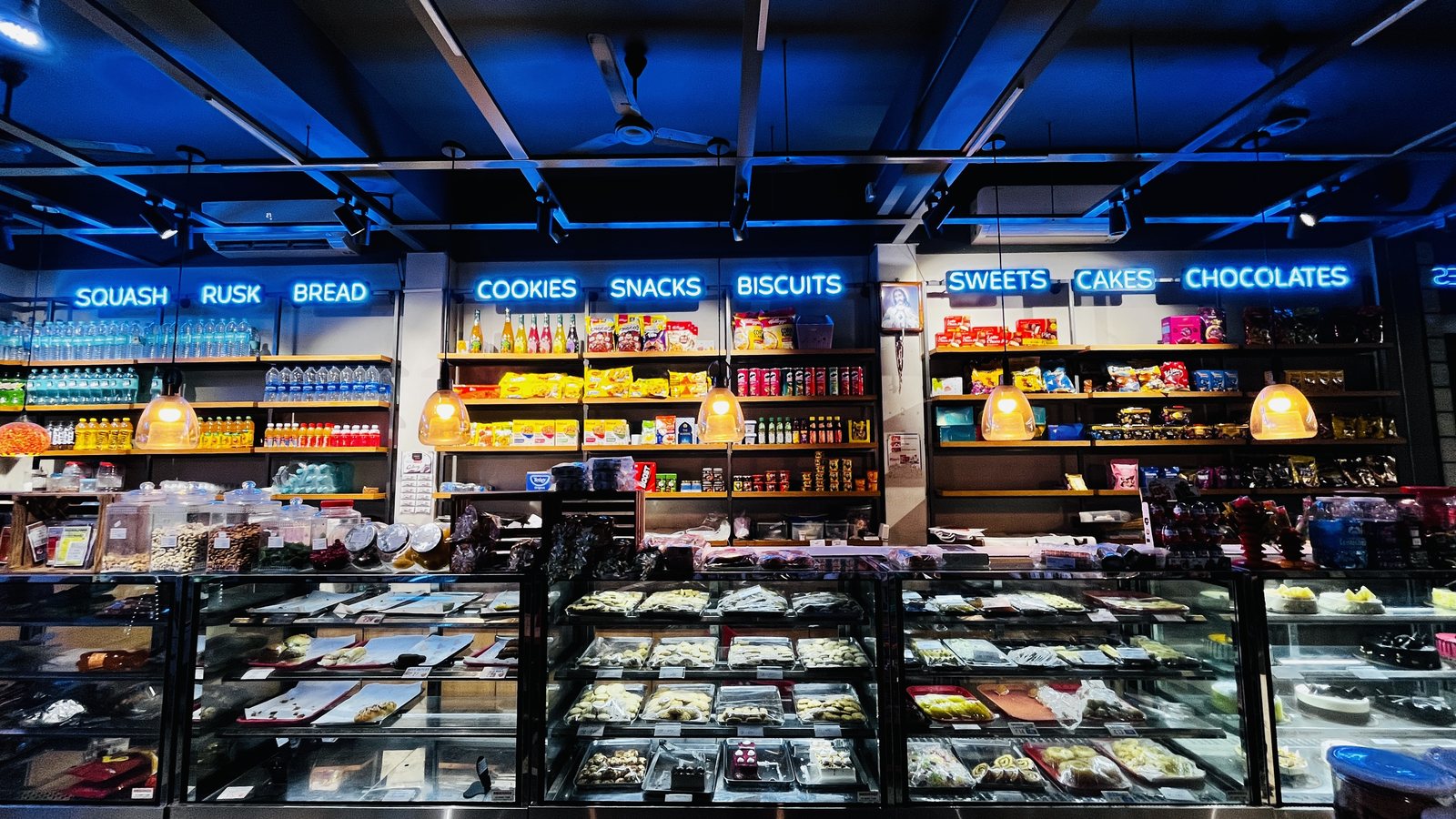 Retail cafe interior with blue ceiling lighting and illuminated shelves